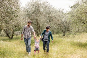 Couple running with toddler girl in garden, Florence, Italy Couple running with toddler girl in garden, Florence, Italy